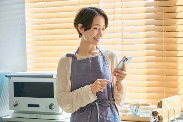 スマホを笑顔で見ている女性